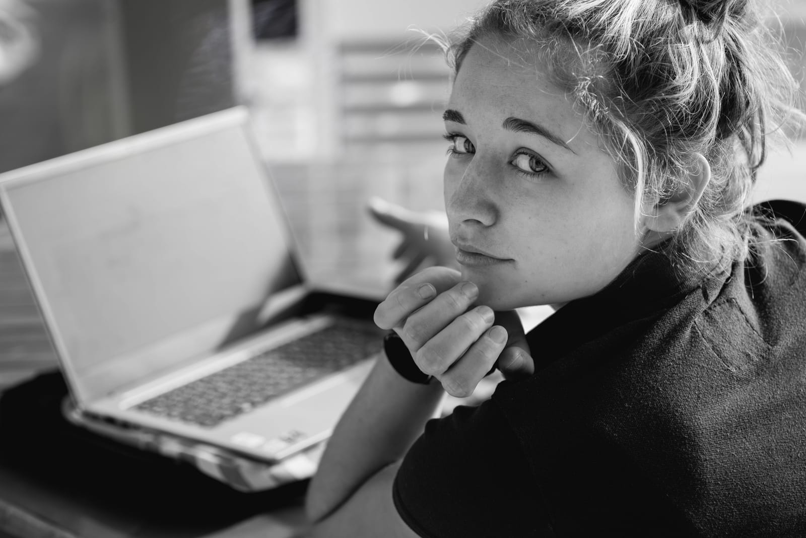 A young au pair looking at the camera while studying online