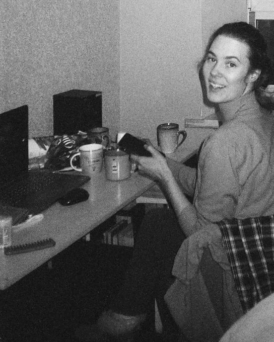 A young au pair smiling over her shoulder while studying at night